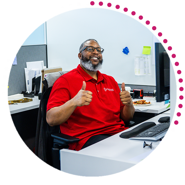 Person smiling and giving thumbs up from their cubicle