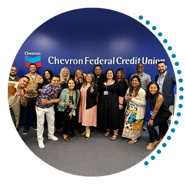 Group of people standing in front of a Chevron Federal Credit Union logo wall